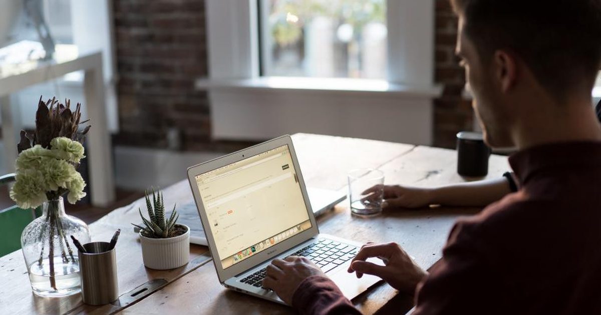 Hands typing on a laptop at a desk
