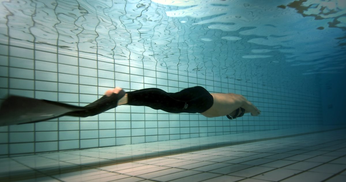 A free diver with a monofin gliding underwater